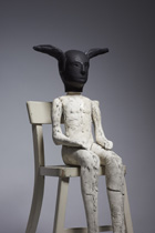 Seated figure with black ears 